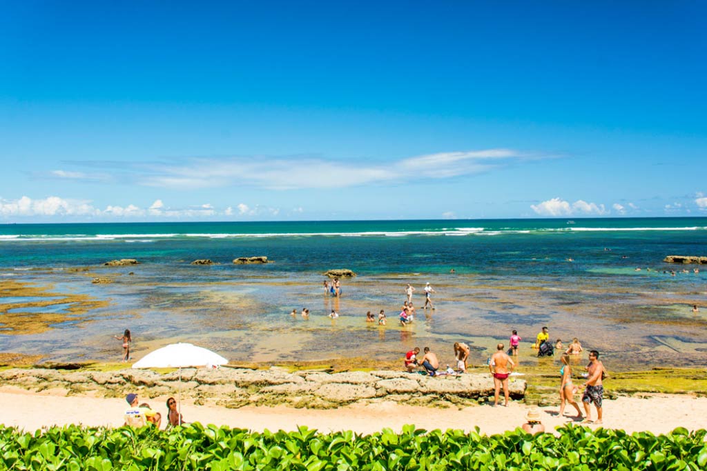 imagem ilustra a praia do mucugê, com a maré baixa e as suas piscinas naturais
